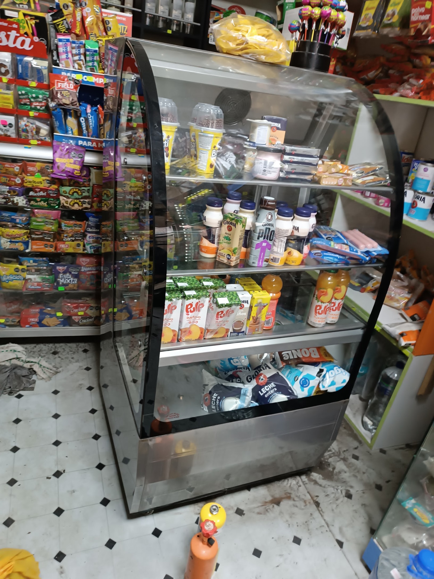 Vitrina refrigerada curva con lácteos y jugos en bodega atendida por servicio técnico en Lima