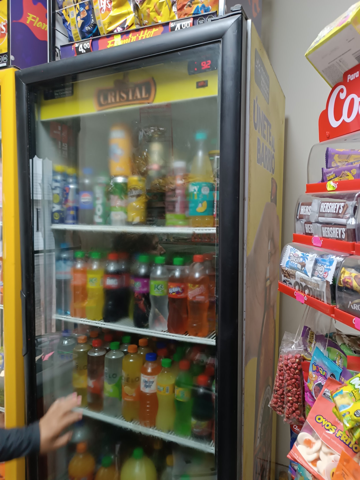 Visicooler comercial de bebidas con lateral amarillo y avisos de cerveza Cristal en bodega atendida en Lima